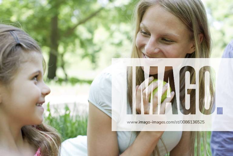 Mother and daughter outdoors, looking at each other