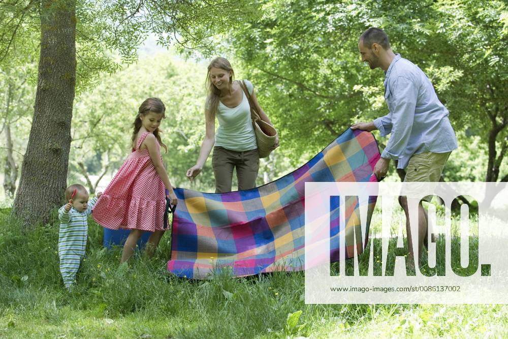 Family preparing for picnic in meadow