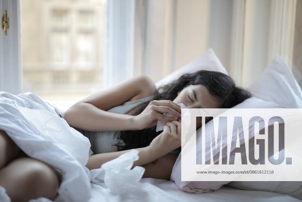 Sick young woman with a cold lying in bed Budapest, Hungary CR_MIPI260712B-2074777-01 ,model released, Symbolfoto ,property released