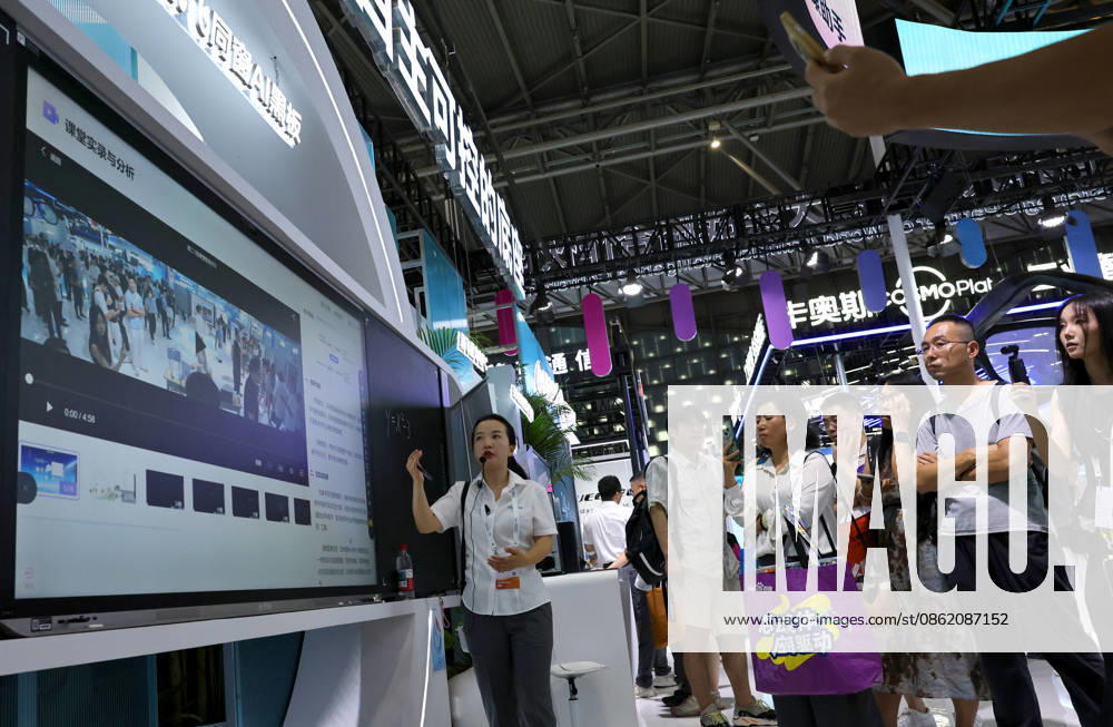 (260719) -- SHANGHAI, July 19, 2026 -- A staff member (L) introduces functions of the iFlytek AI blackboard during the 2026 World AI Conference and High-Level Meeting on Global AI Governance in Shanghai, east China, July 19, 2026. The event scheduled from Friday to Monday showcases exhibitions of a number of AI agent hardware and system products, highlighting the transition of next-generation AI from a tool to an intelligent partner, empowering various industries and everyday life. ) CHINA-SHANGHAI-WORLD AI CONFERENCE-AI PRODUCTS (CN) FangxZhe