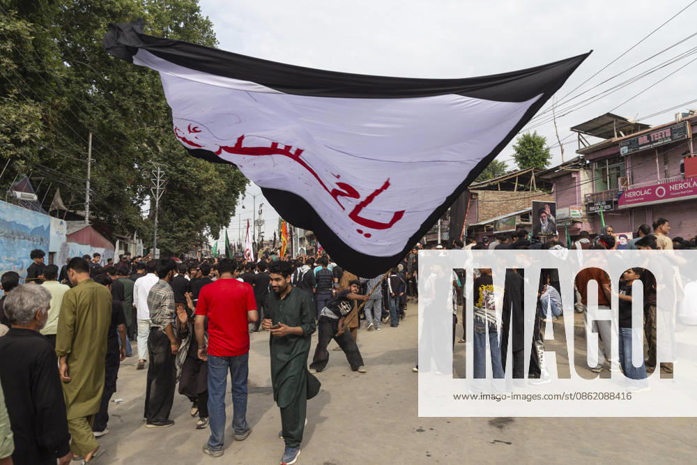 A Shiite Muslim waves a religious flag during a procession on the fourth day of Safar in Magam. Safar, the second month of the Islamic calendar, follows Muharram and continues the mourning of Imam Hussain. According to Shia tradition, the 4th of safar, 61 AH, marks the imprisonment of the Prophet s household (Ahl al-Bayt) in Kufa under the orders of Ubaydullah ibn Ziyad after the Battle of Karbala. Budgam India - ZUMAa205 20260719_zip_a205_001