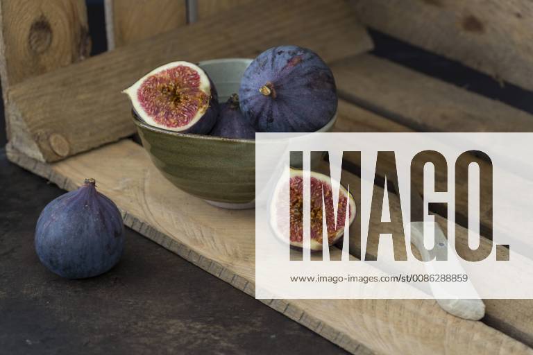 Sliced and whole fresh figs, kitchen knife and wooden box JUNF01224