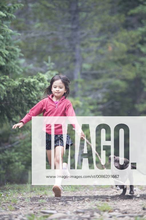 A girl runs with her puppy in the wilderness., Nederland Colorado USA model released Symbolfoto