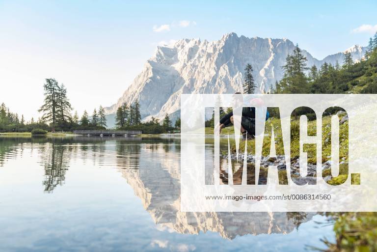 Austria, Tyrol, Hiker taking a break, crouching by the lake model released Symbolfoto DIGF04795