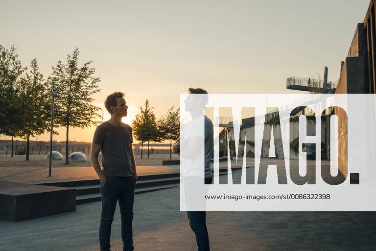 Two friends meeting at sunset, spending the evening talking model released Symbolfoto GUSF01037