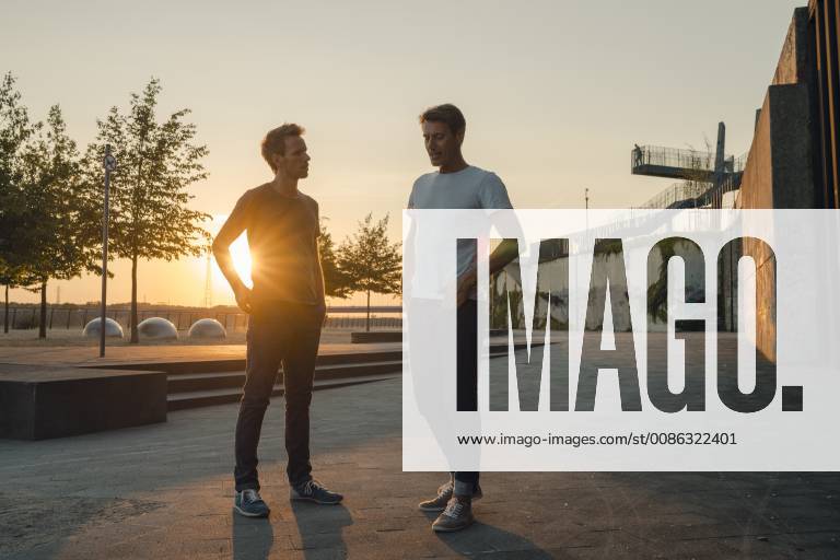 Two friends meeting at sunset, spending the evening talking model released Symbolfoto GUSF01038