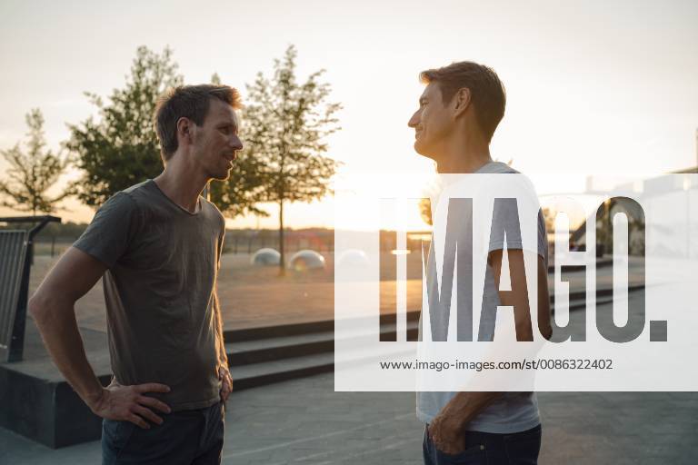 Two friends meeting at sunset, spending the evening talking model released Symbolfoto GUSF01039