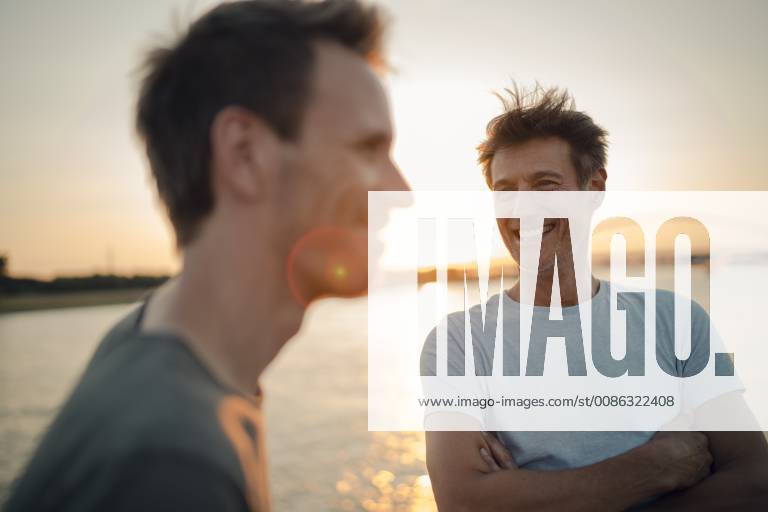 Two friends meeting at sunset, spending the evening talking model released Symbolfoto GUSF01042