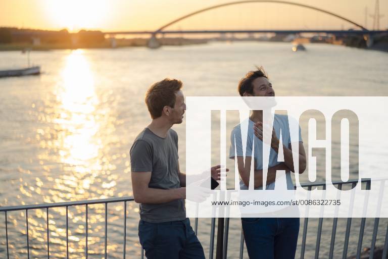 Two friends meeting at sunset, spending the evening talking model released Symbolfoto GUSF01206