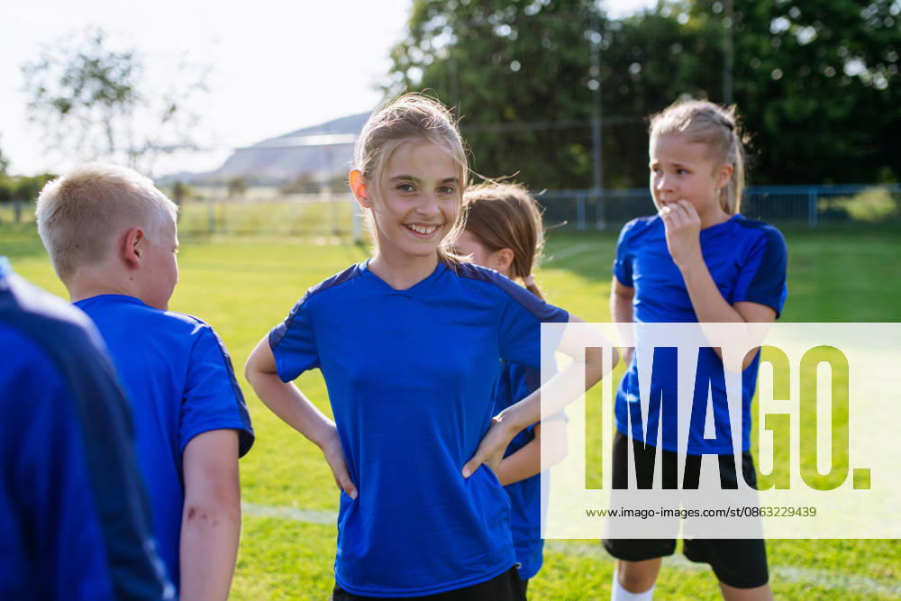 Mixed youth football team standing together on soccer field before training. Mixed youth football team standing together on soccer field before training session. model released
