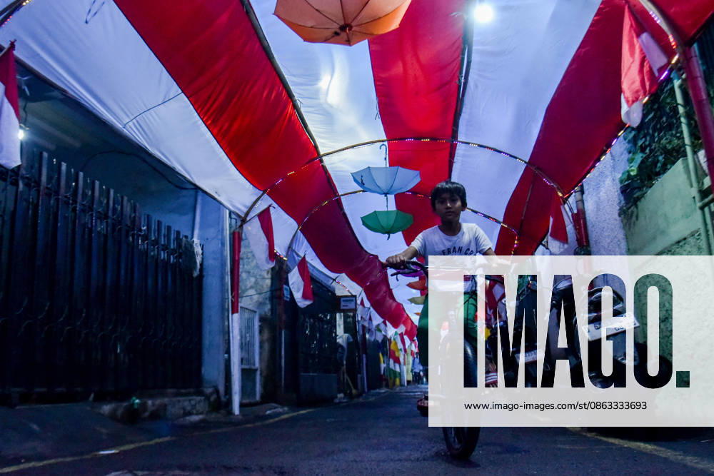 A child rides past on a bicycle beneath a 55 meter long red and white cloth to celebrate the 81st anniversary of Indonesia s Independence Day, amidst a neighborhood decorated with umbrellas and lights in Bandung, Indonesia. Bandung Indonesia - ZUMAr272 20260804_zip_r272_004