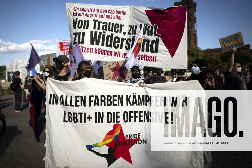 CSD-Anschlag Solidaritaets-Demo DEU, Deutschland, Germany, Berlin, 02.08.2026 Teilnehmer mit Transparent von Pride Rebellion und Von Trauer zu Wut Zu Widerstand und Symbol einer Regenbogenfahne an der Trauerveranstaltung und Gedenkveranstaltung im Rahmen einer Demonstration und Kundgebung in Solidaritaet fuer die Opfer des islamistischen CSD-Anschlags und dessen Abbruch unter dem Motto Angriff auf den CSD Berlin Von Trauer zu Wut Zu Widerstand und Liebe ist staerker als Hass am Alexanderplatz in Berlin Deutschland . Bei dem Terroranschlag im Park Tiergarten starb ein Mensch und weitere wurden teils schwer verletzt. Der Anschlag erfolgte auf der Demonstration der schwul-lesbischen Gedenkparade Christopher Street Day CSD Parade Berlin Pride 2