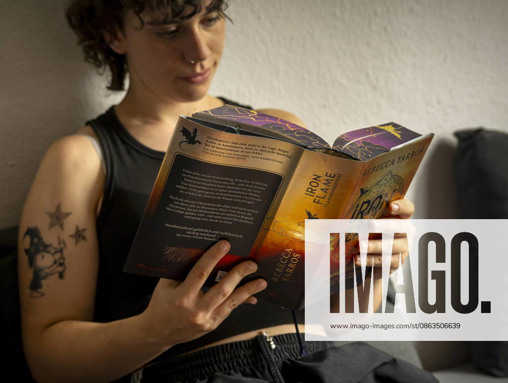 Buchreihe von Rebecca Yarros, IRON FLAME, ein Teenager in Bad Wörishofen in Bayern sitzt auf ihrem Sofa und liest ihr Spannendes Buch. (Modelreleased) 07.08.2026, Jugendbücher 07.08.2026, Jugendbücher