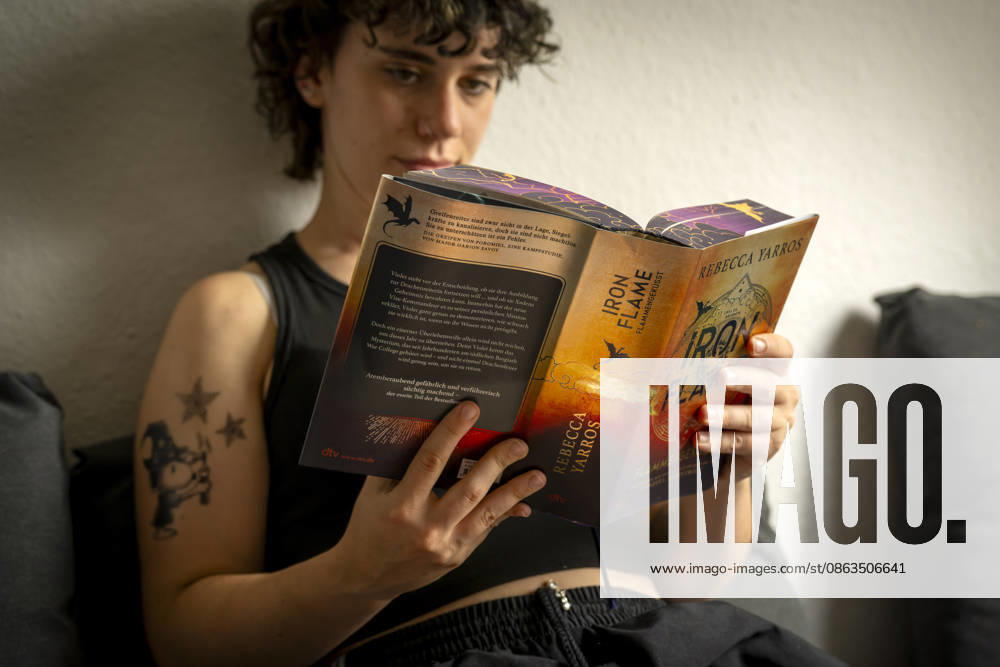 Buchreihe von Rebecca Yarros, IRON FLAME, ein Teenager in Bad Wörishofen in Bayern sitzt auf ihrem Sofa und liest ihr Spannendes Buch. (Modelreleased) 07.08.2026, Jugendbücher 07.08.2026, Jugendbücher