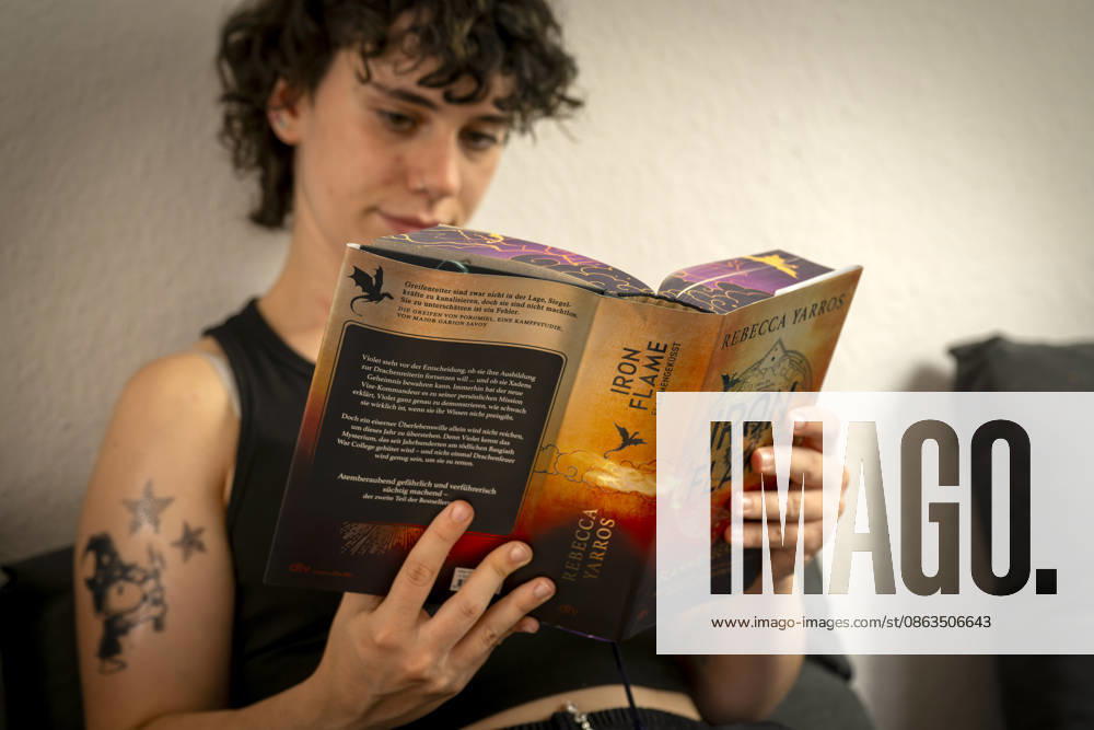Buchreihe von Rebecca Yarros, IRON FLAME, ein Teenager in Bad Wörishofen in Bayern sitzt auf ihrem Sofa und liest ihr Spannendes Buch. (Modelreleased) 07.08.2026, Jugendbücher 07.08.2026, Jugendbücher