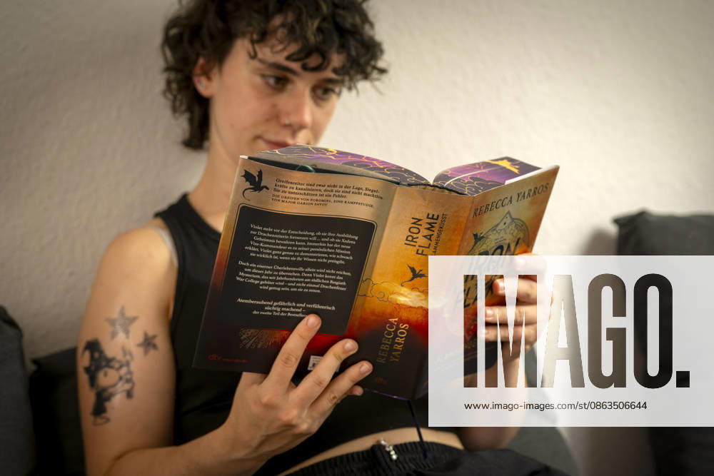 Buchreihe von Rebecca Yarros, IRON FLAME, ein Teenager in Bad Wörishofen in Bayern sitzt auf ihrem Sofa und liest ihr Spannendes Buch. (Modelreleased) 07.08.2026, Jugendbücher 07.08.2026, Jugendbücher