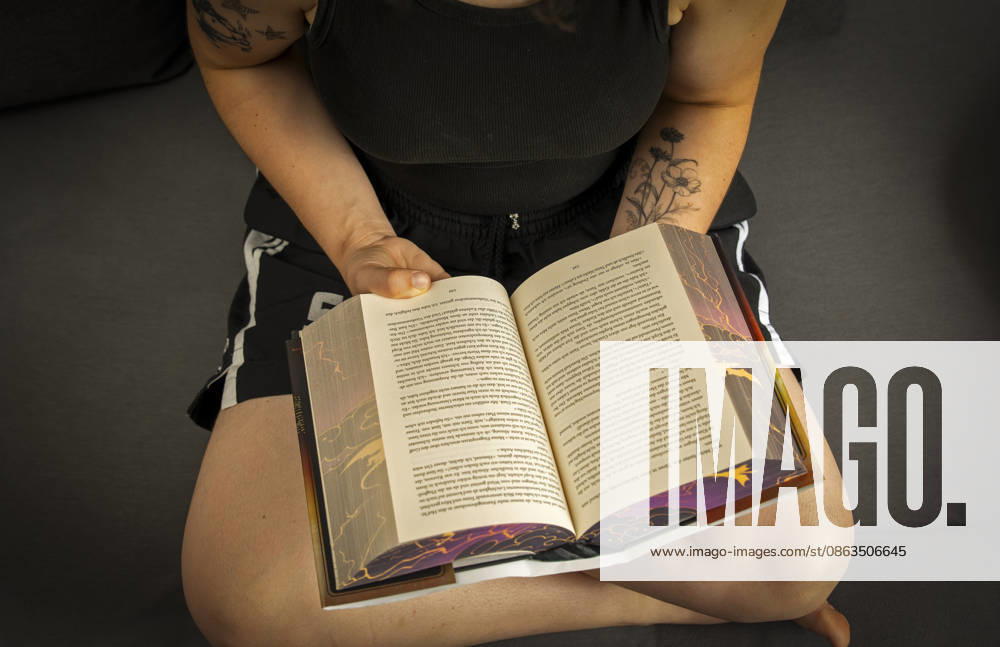 Buchreihe von Rebecca Yarros, IRON FLAME, ein Teenager in Bad Wörishofen in Bayern sitzt auf ihrem Sofa und liest ihr Spannendes Buch. (Modelreleased) 07.08.2026, Jugendbücher 07.08.2026, Jugendbücher