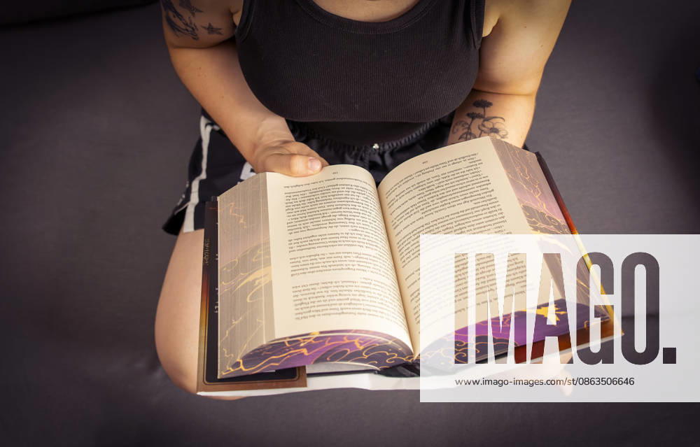 Buchreihe von Rebecca Yarros, IRON FLAME, ein Teenager in Bad Wörishofen in Bayern sitzt auf ihrem Sofa und liest ihr Spannendes Buch. (Modelreleased) 07.08.2026, Jugendbücher 07.08.2026, Jugendbücher