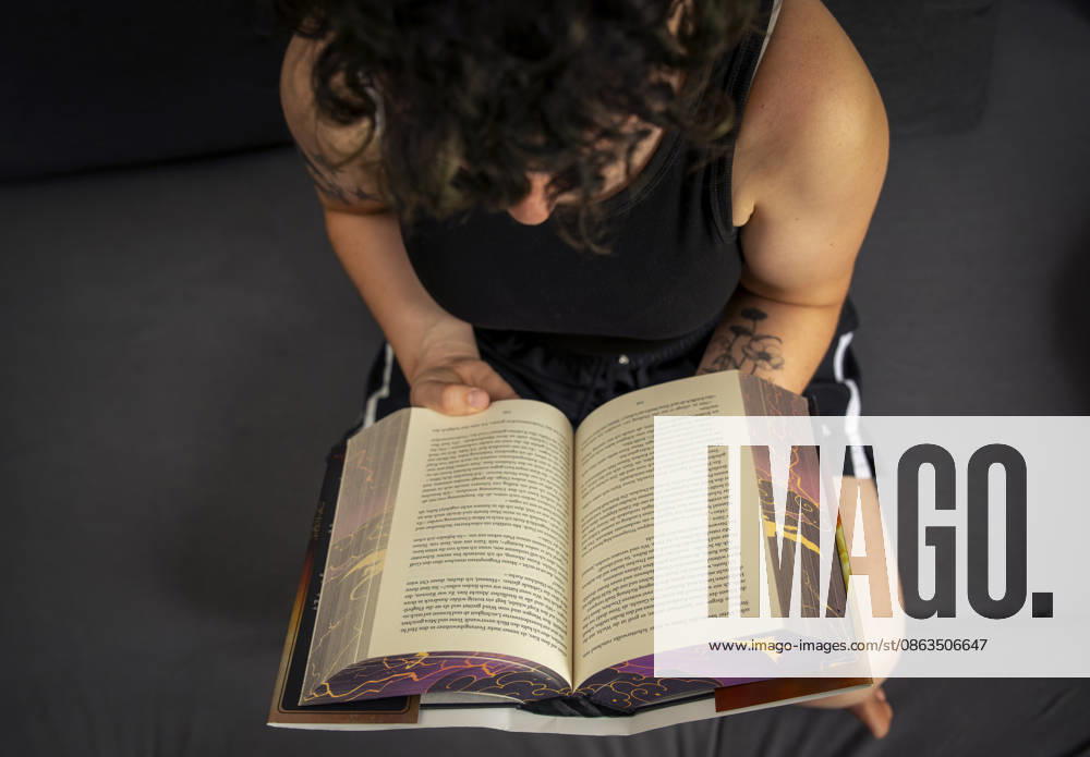 Buchreihe von Rebecca Yarros, IRON FLAME, ein Teenager in Bad Wörishofen in Bayern sitzt auf ihrem Sofa und liest ihr Spannendes Buch. (Modelreleased) 07.08.2026, Jugendbücher 07.08.2026, Jugendbücher