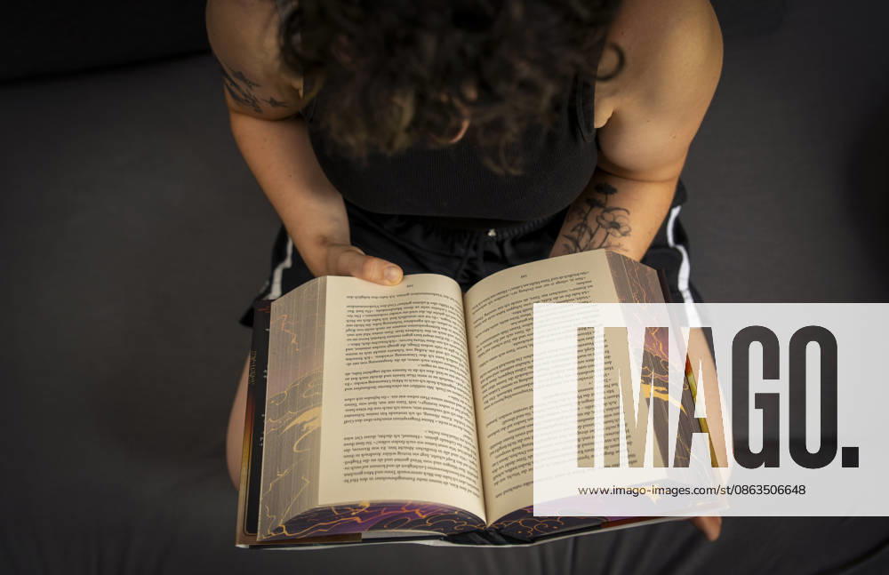 Buchreihe von Rebecca Yarros, IRON FLAME, ein Teenager in Bad Wörishofen in Bayern sitzt auf ihrem Sofa und liest ihr Spannendes Buch. (Modelreleased) 07.08.2026, Jugendbücher 07.08.2026, Jugendbücher