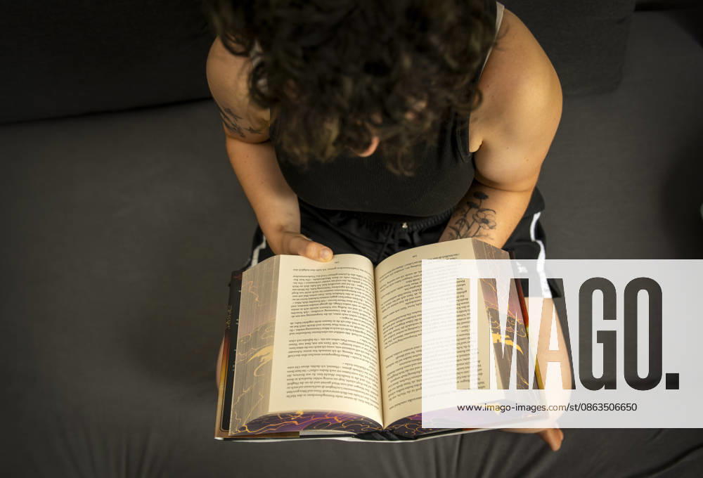 Buchreihe von Rebecca Yarros, IRON FLAME, ein Teenager in Bad Wörishofen in Bayern sitzt auf ihrem Sofa und liest ihr Spannendes Buch. (Modelreleased) 07.08.2026, Jugendbücher 07.08.2026, Jugendbücher