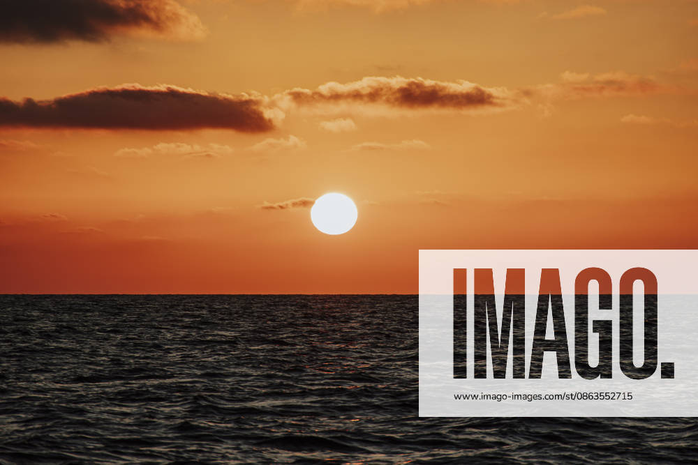 The bright sun sets over the calm ocean water, GMLF02273