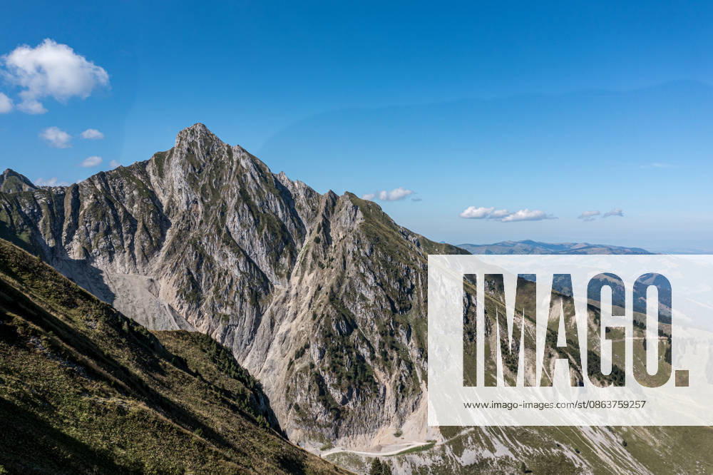 Zackiger Alpengipfel und grasbewachsener Bergrücken im Berner Oberland - dramatische Berglandschaft der Schweizer Alpen