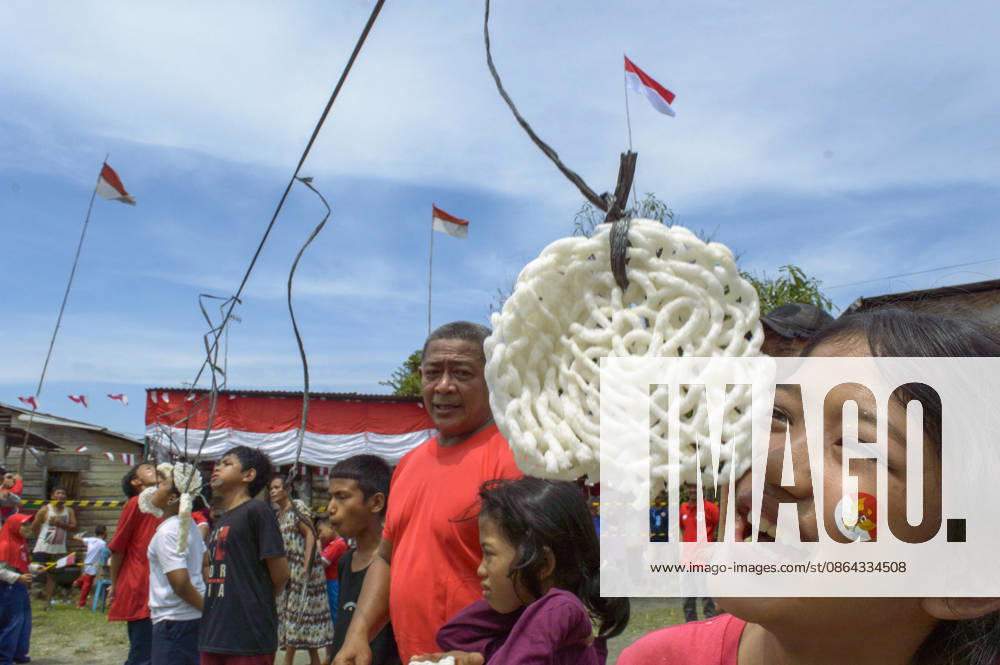 Indonesia s 81st Independence Day Festive Determination - Medan Children from Neighborhood IV in Karang Sari village, Medan Polonia, Medan, North Sumatra, Indonesia, eagerly participated in a Lomba Makan Kerupuk (krupuk-eating contest) during the celebrations for Indonesia s 81st Independence Day. On August 17, 2026, the young participants, adorned with Indonesian flag stickers on their cheeks, reached upward to grab hanging crackers without using their hands, while community festivities continued around them. Photo by Aditya Sutanta ABACAPRESS.COM Medan Indonesia