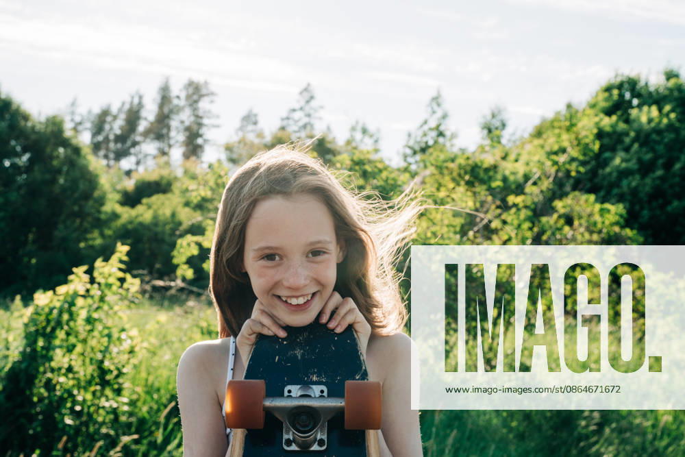 Smiling girl with freckles holds skateboard outdoors Stockholm, Stockholm County, Sweden CR_RABE260819F9-2044390-01 ,model released, Symbolfoto ,property released