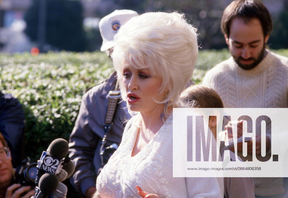 Dolly Parton speaks to reporters after a court recess during her infringement court case involving her hit song, 9 to 5 at Los Angeles Federal Court on December 13, 1985.