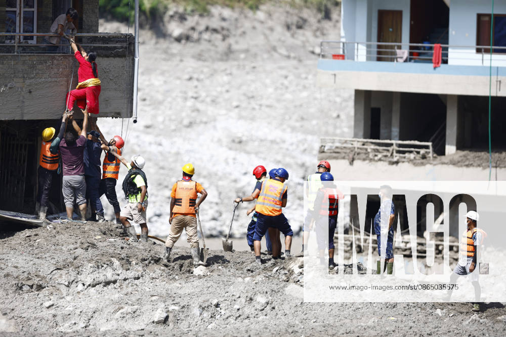 A woman climbs on top of her home to retrieve goods following flash floods at Devighat in Bidur Municipality, Nuwakot district, Nepal, on Thursday, August 27, 2026. The floods, triggered by a glacial collapse and debris flow upstream, have killed at least 270 people and left 826 others out of contact, according to Nepalese authorities, with search and rescue operations continuing. Nuwakot Nepal - ZUMAg200 20260828_zap_g200_002
