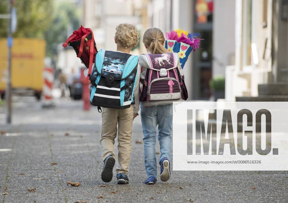 IMAGO Creative: Gesellschaft, Schule, Schulanfang Zwei Kinder mit Schultuete auf Schulweg, von hinten (model-released)
