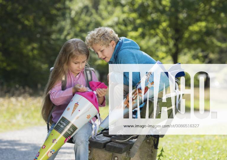 Zwei Kinder packen Schultuete aus (model-released)