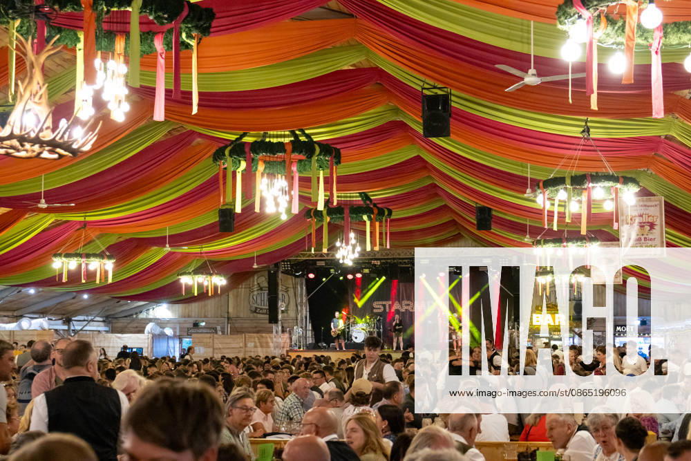 Eröffnung Plärrer in Augsburg. Ein voll besetztes Festzelt auf dem Augsburger Herbstplärrer. Zahlreiche Besucher feiern in Dirndl und Lederhosen, trinken Bier und genießen die ausgelassene Stimmung des traditionellen Volksfests