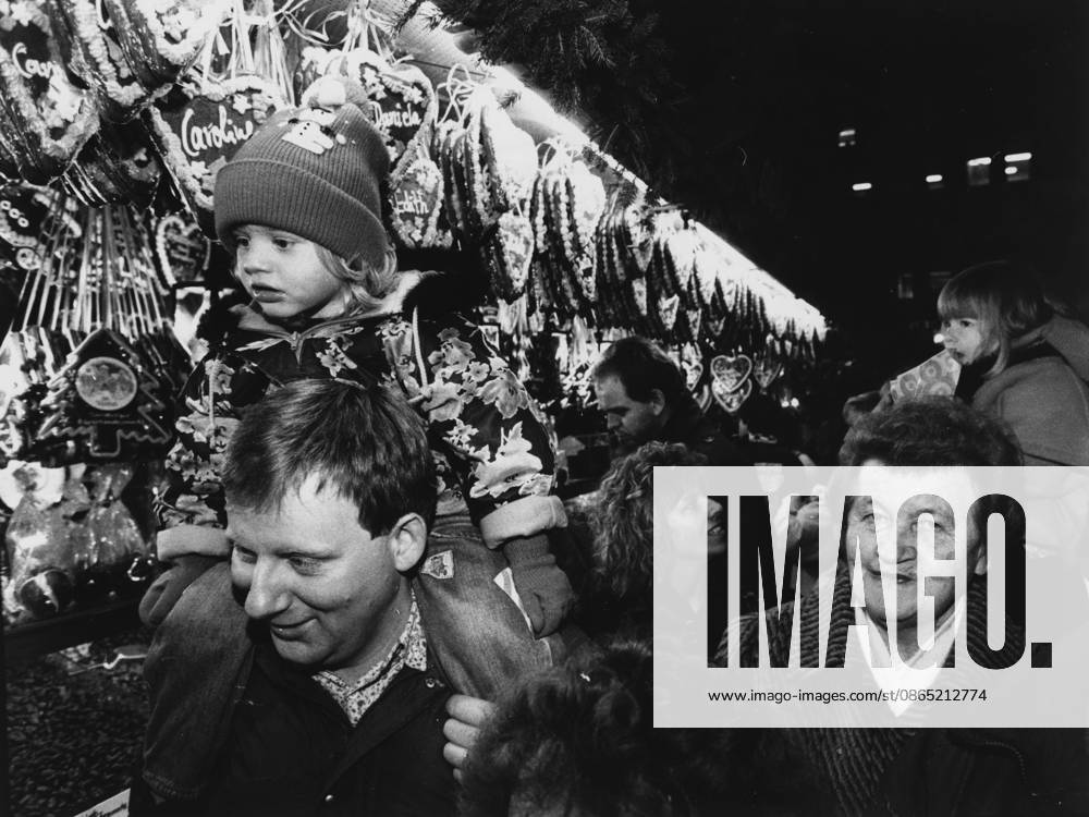 Nürnberger Christkindlesmarkt Ein Mann trägt ein Kind auf den Schultern auf dem Nürnberger Christkindlesmarkt, im Hintergrund ein Stand mit Lebkuchenherzen, 27.11.1992 Nürnberg Bayern Deutschland