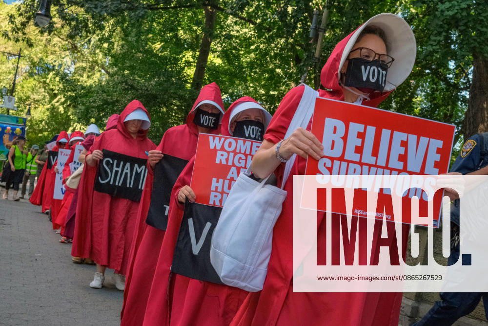 A line of women dressed as handmaids holds protest signs during a silent demonstration by the National Handmaiden Army near Central Park in New York City. The demonstrators protested President Donald Trump and government policies while advocating for womens rights, reproductive rights, bodily autonomy, voting and an end to gender discrimination. New York USA - ZUMAh156 20260829_znp_h156_006