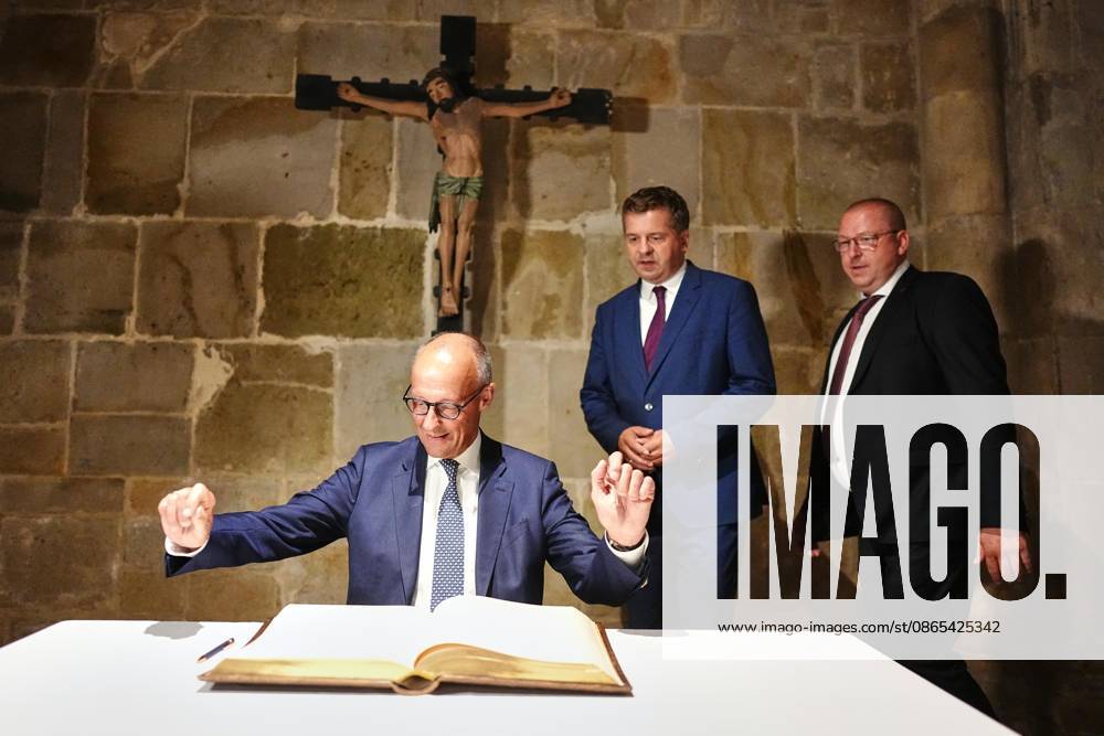 Quedlinburg, Sachsen-Anhalt, Deutschland, 31.08.2026: Bundeskanzler Friedrich Merz (CDU) ist zum ersten Wahlkampfauftritt vor der Landtagswahl 2026 in die Stiftskirche gekommen und trägt sich dort vor einem Jesus-Kreuz in das Goldene Buch der Stadt ein. Im Hintergrund Ministerpräsident Sven Schulze (CDU). (Foto: Kay Nietfeld, Pool)