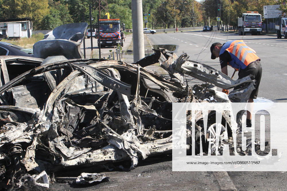 A man sweeps a street near a destroyed car after a Russian Banderol cruise missile attack, Dnipro, Ukraine, September 10, 2026. Russian forces launched a double strike on the city with S8000 Banderol missiles, damaging a food industry facility. A fire broke out near the site, destroying 12 passenger cars and two minibuses. Two people were killed and at least five injured in the attack. (Photo by Mykola Miakshykov Ukrinform) Aftermath of Russian attack on Dnipro on September 10, 2026