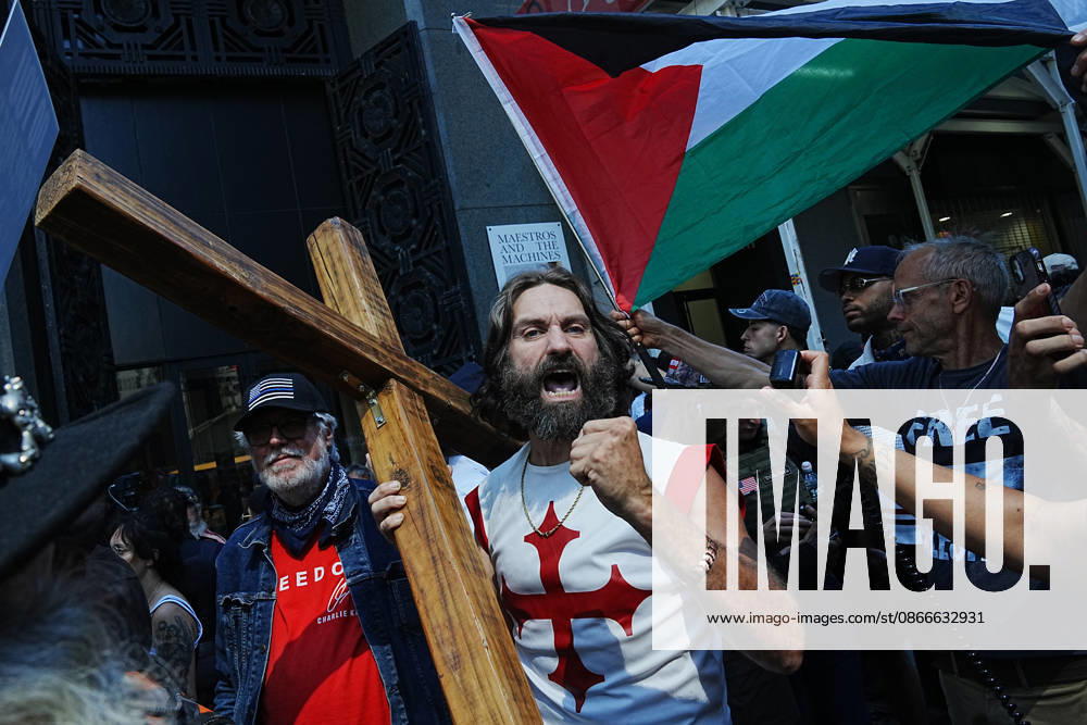 A man carrying a cross chants as part of an anti-Muslim rally lead by white supremacist JAKE LANG near the 9 11 Memorial on the 25th anniversary of the attacks of September 11 on September 11, 2026 in New York. New York USA - ZUMAb148 20260911_zap_b148_020