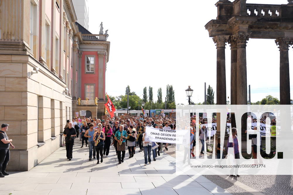 Demonstranten laufen mit Banner Netzwerk Omas gegen Rechts Brandenburg um den Landtag während einer Demonstration für die Überprüfung rechtsextremer Parteien durch das Bundesverfassungsgericht, Alter Markt, Potsdam, 12. September 2026. Prüf-Demo in Potsdam