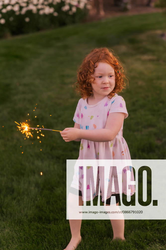 Young girl with curly red hair holding lit sparkler Eagle, Idaho, United States CR_PHZD260913-2107603-01 ,model released, Symbolfoto ,property released