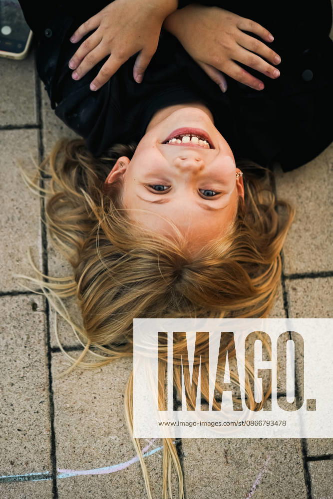 Happy young girl lying upside down on sidewalk Minsk, Minsk Region, Belarus CR_YUKI260913-2118452-01 ,model released, Symbolfoto ,property released