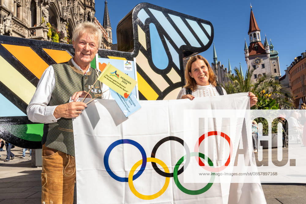 München wird deutscher Olympia-Bewerber, Verena Dietl, Sportbürgermeisterin der Stadt München, bei einer spontanen kleinen Feier vor Olympia-Maskottchen Dackel Waldi auf dem Marienplatz, München, 26. September 2026 Deutschland, München, 26. September 2026, Münchner Olympia-Bewerbung erfolgreich, München wird deutscher Olympia-Bewerber, Verena Dietl, Sportbürgermeisterin der Stadt München, 3. Bürgermeisterin, bei einer spontanen kleinen Feier mit Statement auf dem Marienplatz, mit dabei links ist Peter Mösbauer, Teil des Kommunikationsteams des BLSV, der die Olympia-Bewerbung unterstützt hat, Olympische Flagge, Olympia-Maskottchen Dackel Waldi auf dem Marienplatz, Münchner Olympia-Bewerbung mit drei Meter hohem Riesen-Dackel, Ma