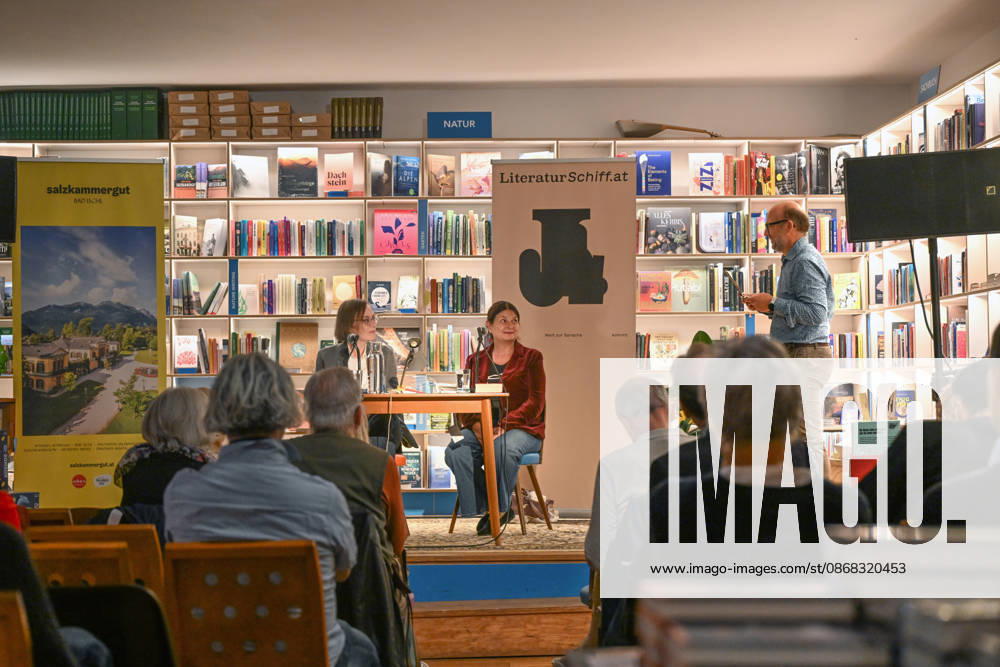 Minifestival AH0J (Literaturfestival) - Tschechien setzt über - der Kulturinitiative Literaturschiff, in der Buchhandlung Kurdirektion in Bad Ischl. Lesungen und Gespräche in Korrespondenz zum Gastauftritt Tschechiens auf der Frankfurter Buchmesse 2026. Es liest die tschechische Schriftstellerin und mehrfache Literaturpreisträgerin Radka Denemarkovich. Die Veranstaltung wrd moderiert von Julia Miesenböck, fotografiert am 30.09.26. Das Bild zeigt den Veranstalter Christian Gsöllradl-Samhabber, der die Schriftstellerin Radka Denemarkovic und die Moderatorin Julia Miesenböck (links) begrüßt 2026 - Minifestival AH0J (Literaturfestival) - Tschechien setzt über - der Kulturinitiative Literaturschiff, in der Buchhandlung Kurdirektion in B