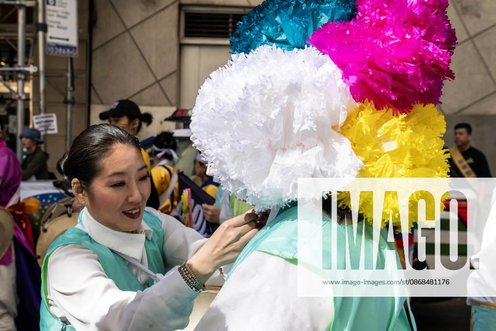 A 2026 NYC Korean Parade participant has their outfit adjusted by a team member. New York USA - ZUMAh214 20261003_znp_h214_013
