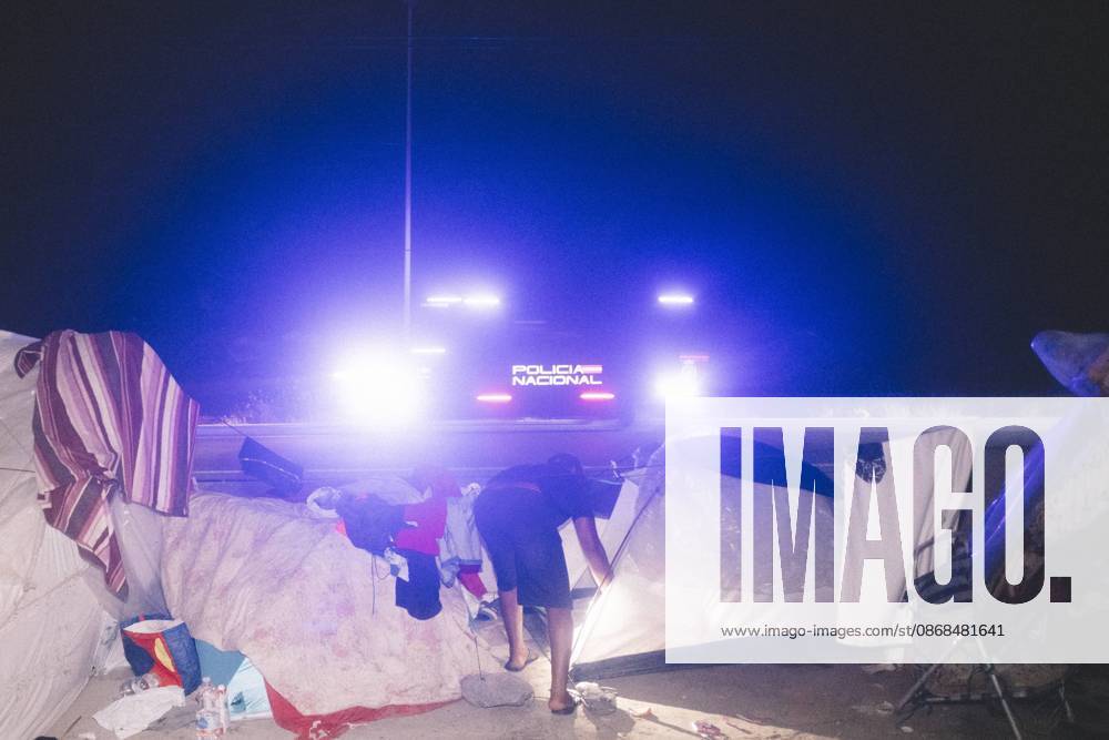 The lights of a police van shine behind a tent at a makeshift migrant camp in Ceuta at night. Riot police escorted firefighters through the camp on the night of October 3 to put out the fires that people living there use to cook their food. Thousands of migrants, most of them young Moroccan men, have been living in makeshift settlements in the Spanish North African enclave of Ceuta since a mass arrival at the end of July 2026 set off a migration and political crisis. Ceuta Spain - ZUMAs392 20261003_zip_s392_007