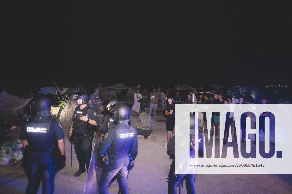 Riot police officers face a group of young men at a makeshift migrant camp in Ceuta at night. Riot police escorted firefighters through the camp on the night of October 3 to put out the fires that people living there use to cook their food. Thousands of migrants, most of them young Moroccan men, have been living in makeshift settlements in the Spanish North African enclave of Ceuta since a mass arrival at the end of July 2026 set off a migration and political crisis. Ceuta Spain - ZUMAs392 20261003_zip_s392_012