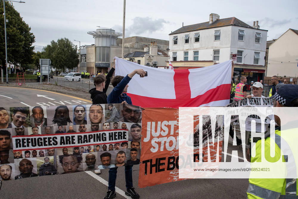 Far-right protesters hold banners and a St George s flag during a demonstration in Dover. Supporters of the English Defence League (EDL) gathered in Dover, UK to march through the town all the way to the harbour. English Defence League is an extreme far-right and Islamophobic organisation. It was founded by Tommy Robinson (pseudonym of Steven Yaxley-Lennon) in 2009. Dover United Kingdom - ZUMAs197 20261003_aaa_s197_257