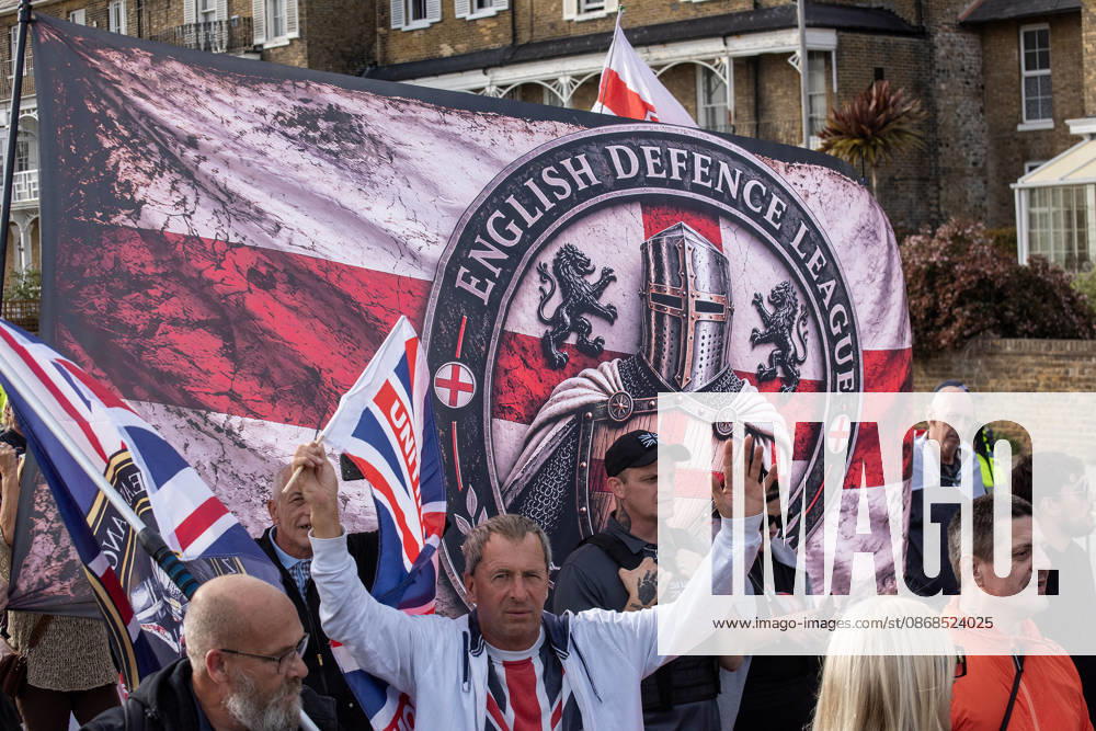 Far-right protesters march with banner and flags to the harbour during a demonstration in Dover. Supporters of the English Defence League (EDL) gathered in Dover, UK to march through the town all the way to the harbour. English Defence League is an extreme far-right and Islamophobic organisation. It was founded by Tommy Robinson (pseudonym of Steven Yaxley-Lennon) in 2009. Dover United Kingdom - ZUMAs197 20261003_aaa_s197_260