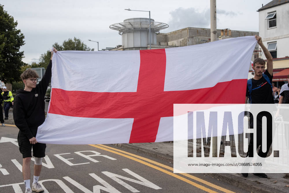 Far-right protesters hold a St George s flag during a demonstration in Dover. Supporters of the English Defence League (EDL) gathered in Dover, UK to march through the town all the way to the harbour. English Defence League is an extreme far-right and Islamophobic organisation. It was founded by Tommy Robinson (pseudonym of Steven Yaxley-Lennon) in 2009. Dover United Kingdom - ZUMAs197 20261003_aaa_s197_263